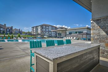 clubhouse with pool and bar with chairs at the estates apartments
